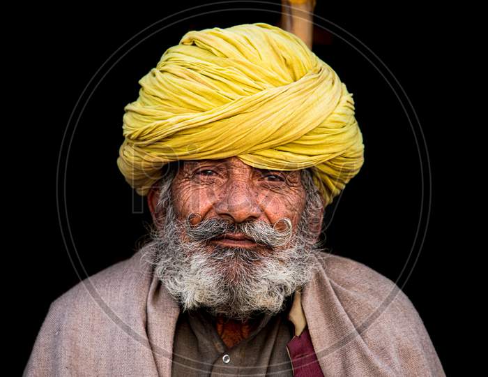 Portrait shot of old Rajasthani man with mustache and turban over head during the pushkar mela