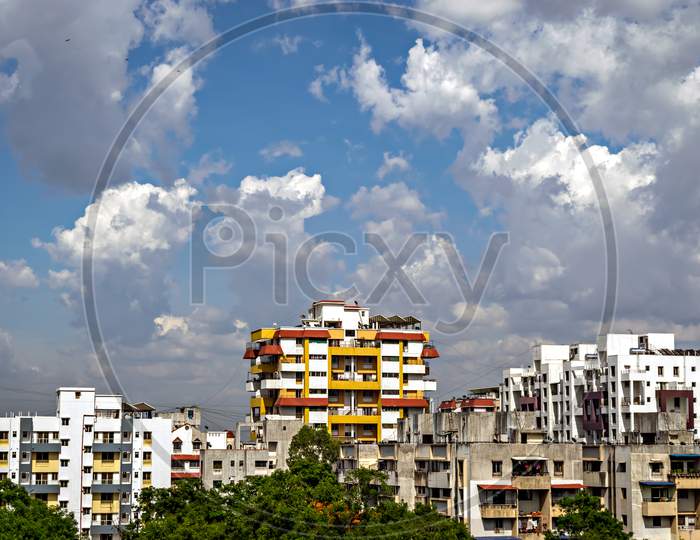 Yellow And Red Highrise Building With Beautiful Cloudscape.
