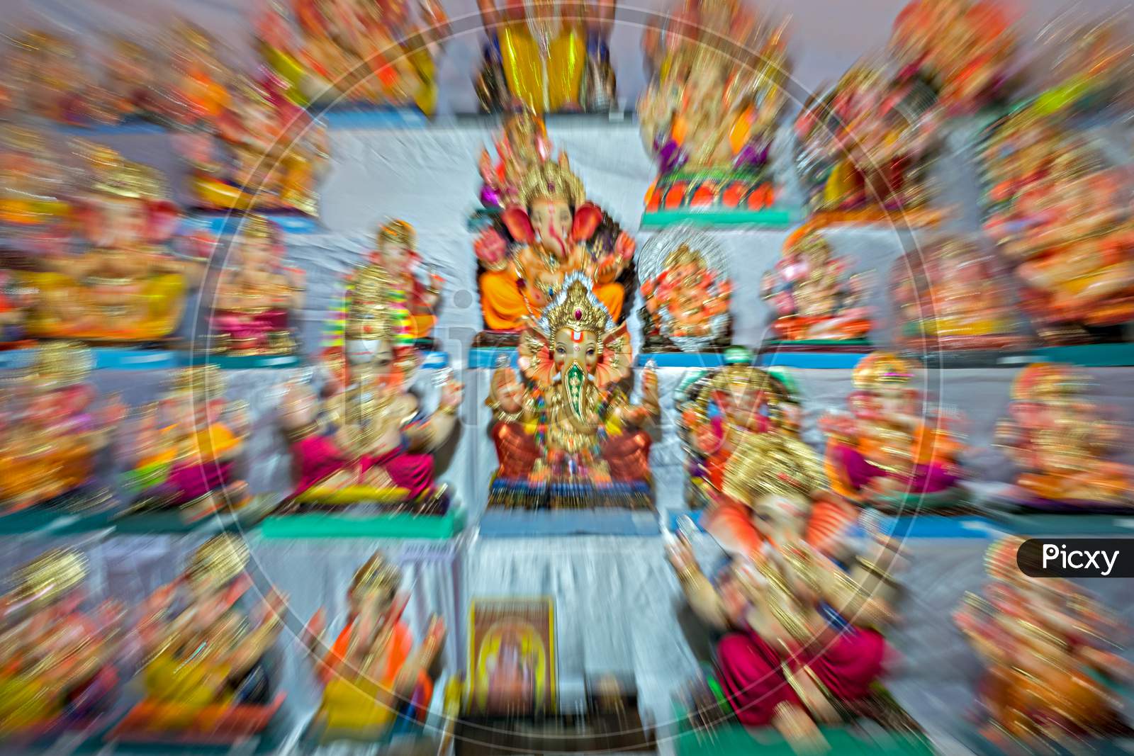 Zoom Burst Photograph Of Lord Ganesh Idol In The Center Of Idols In A Shop.