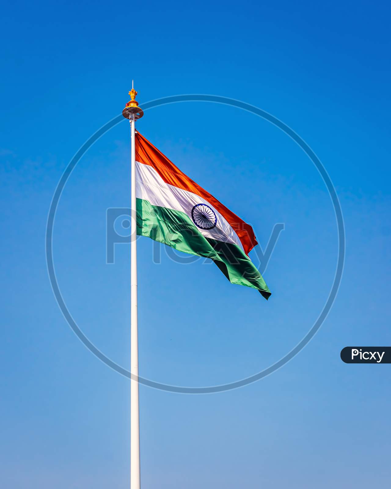 Indian National Flag , Flying High In The Sky On A Clear Blue Background.