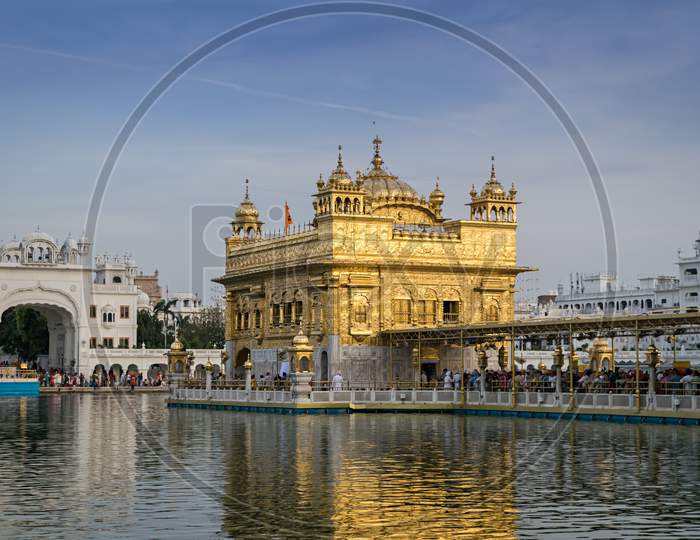 Evening View Of The Golden Temple In Amritsar, India With Beautiful Blue Sky.