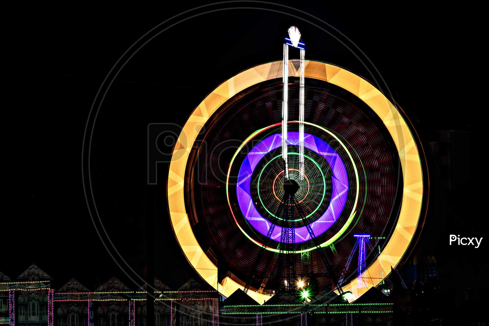 Fun Fair Giant Ferris Wheel Spinning At Night. A Rotating Giant Wheel At Night.