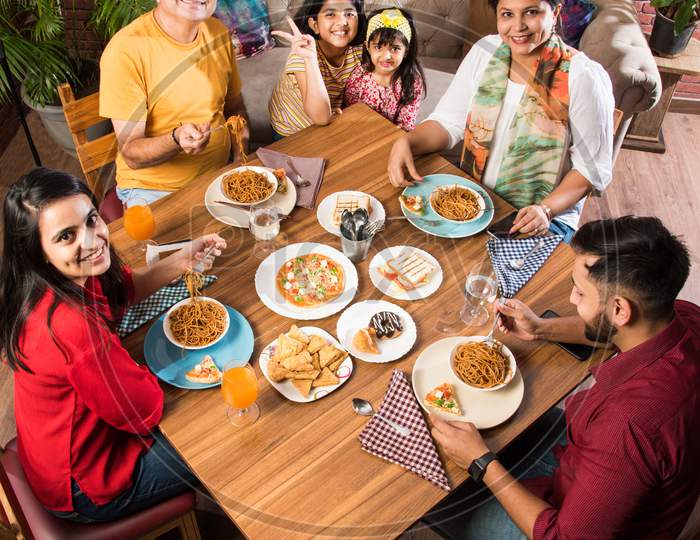 Indian family eating food at home or restaurant