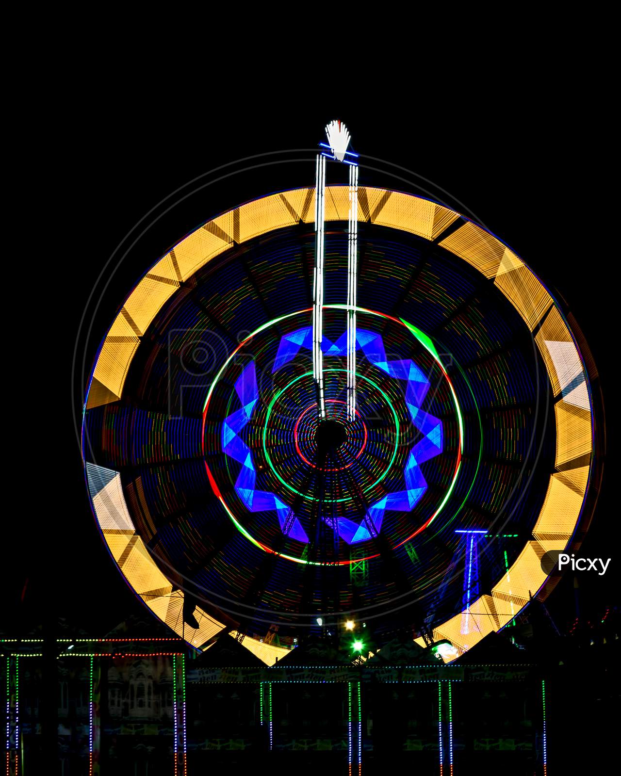 Fun Fair Giant Ferris Wheel Spinning At Night. A Rotating Giant Wheel At Night.