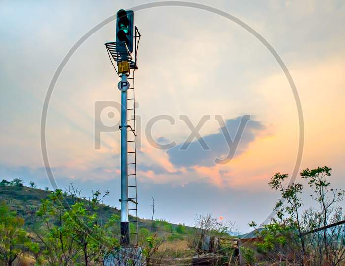 Railway Signal Post Indicating Green Signal On A Backdrop Of Beautiful Evening Sunset.