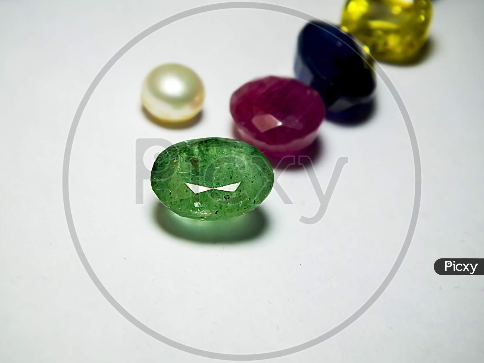 A close up photo of a Green emerald on a gems store shop.
