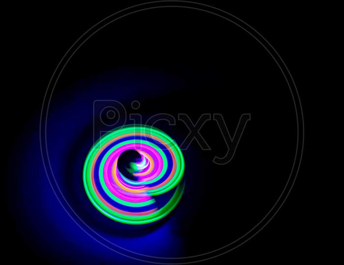 Long Exposure Photograph Of A Light Spinning Top With Black Background.