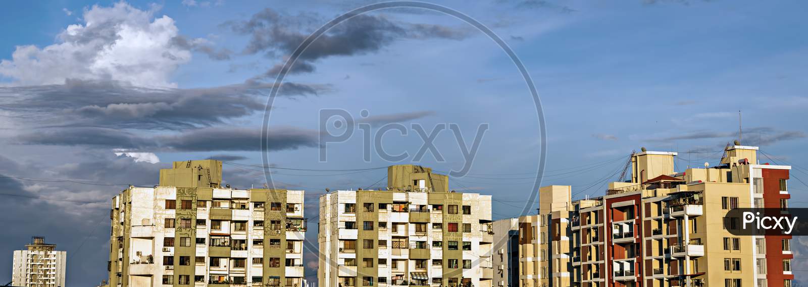 Panorama Image Of Tall Buildings In City With Beautiful Blue Monsoon Clouds.
