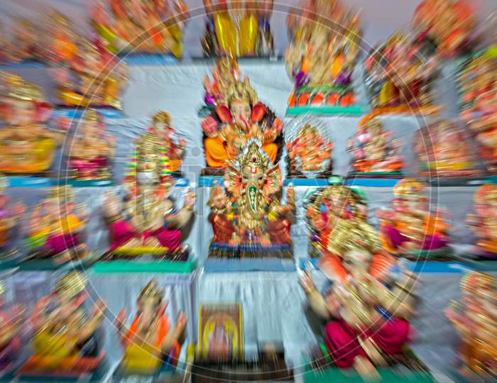 Zoom Burst Photograph Of Lord Ganesh Idol In The Center Of Idols In A Shop.