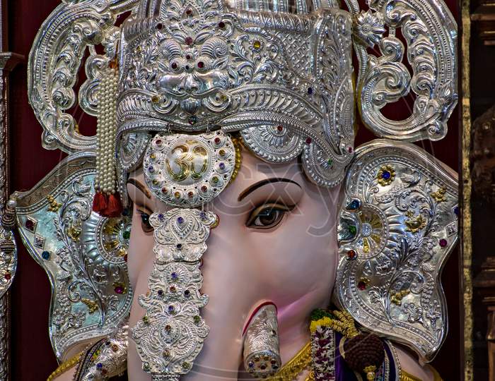 Close Up Portrait View Of Decorated And Garlanded Idol Of Hindu God Ganesha.