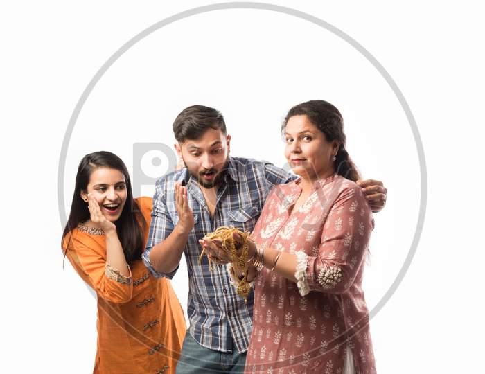 Gold Loan Or Mortgage Concept - Indian Mother With Son And Daughter Holding Gold Jewellery
