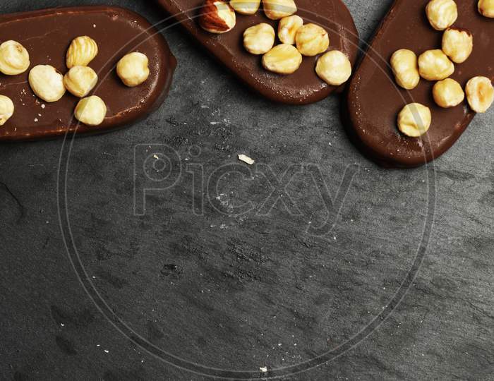 Top View Of Chocolate Ice Creams On A Dark Slate Background With Hazelnuts. Flat Lay . Food Menu Concept