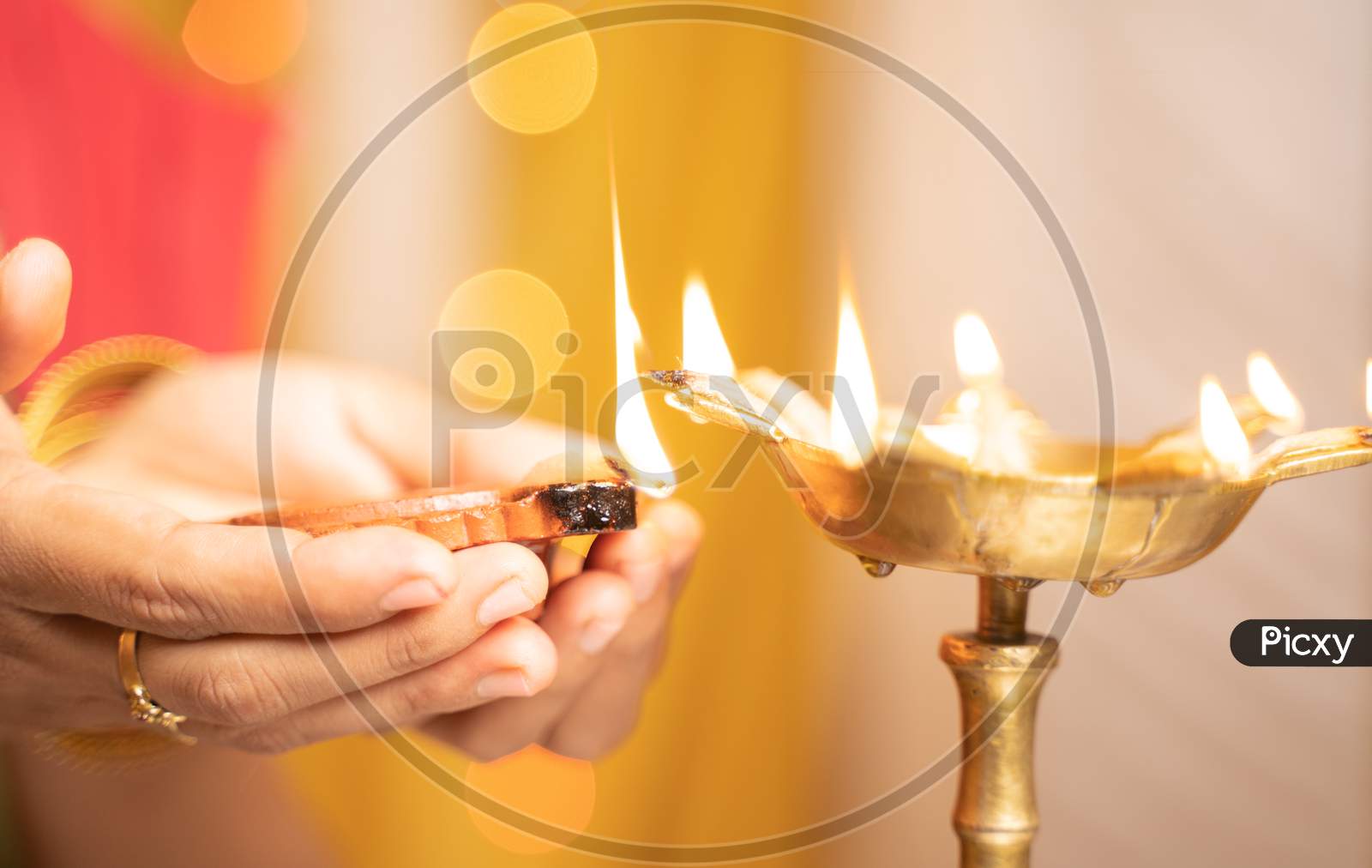 Closeup Of Woman Hands Lighting Lantern Diya Or Lamp During Festival Ceremony - Concept Of Traditional Indian Festival And Ritual Celebrations.
