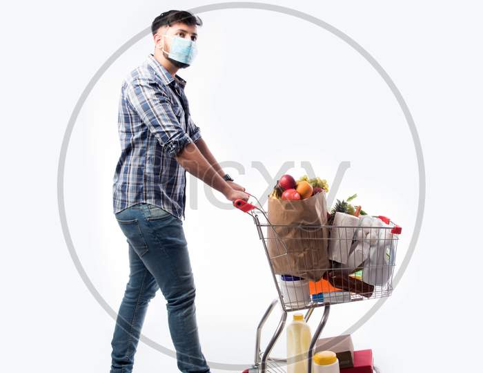 Indian Asian Young Man Wearing Face Mask And Pushing Shopping Trolly Or Cart