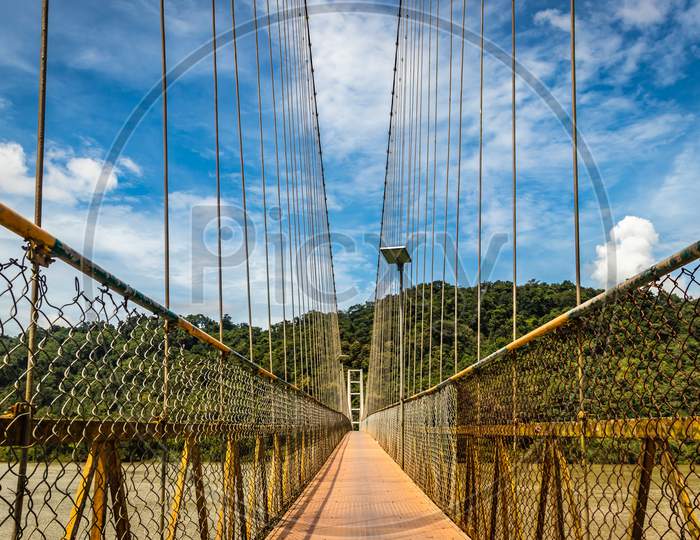 Suspension Iron Bridge Isolated With Bright Blue Sky From Unique Different Angle