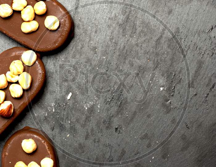 Top View Of Chocolate Ice Creams On A Dark Slate Background With Hazelnuts. Flat Lay . Food Menu Concept