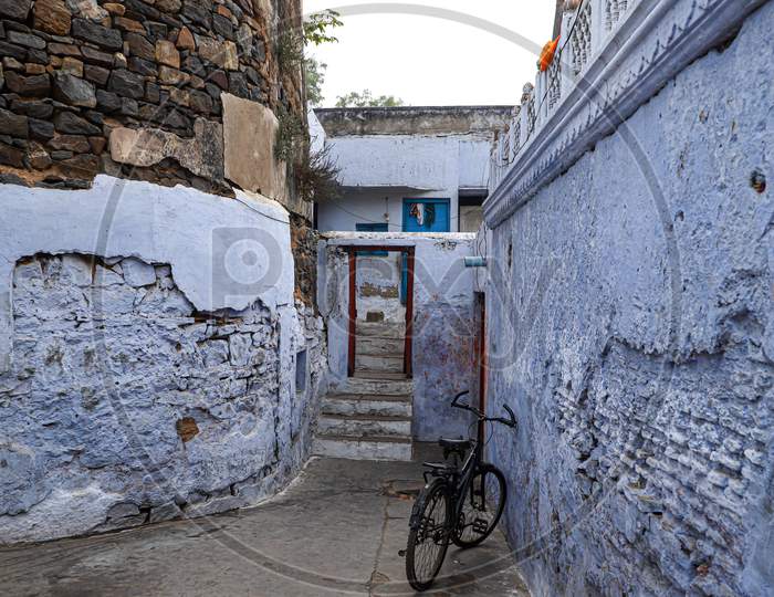 Old bicycle at the wall of blue house in streets  of bharatpur,rajasthan