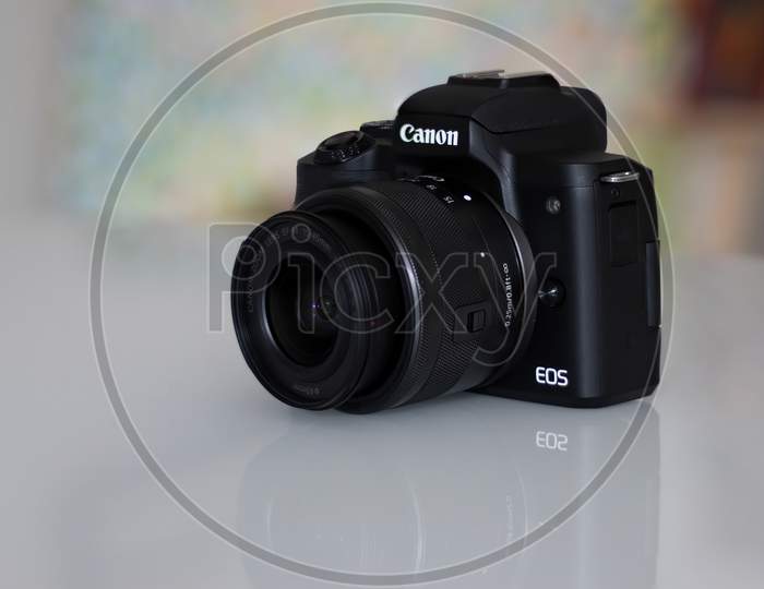 Frankfurt, Germany - 26th August 2020: A german photographer takes pictures of his old Canon EOS M50 with the KIT lens and additional equipment in order to sell it, showing the camera body with lens.
