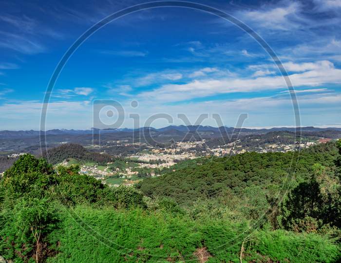 City View With Mountain Range And Bright Blue Sky From Hill Top At Day