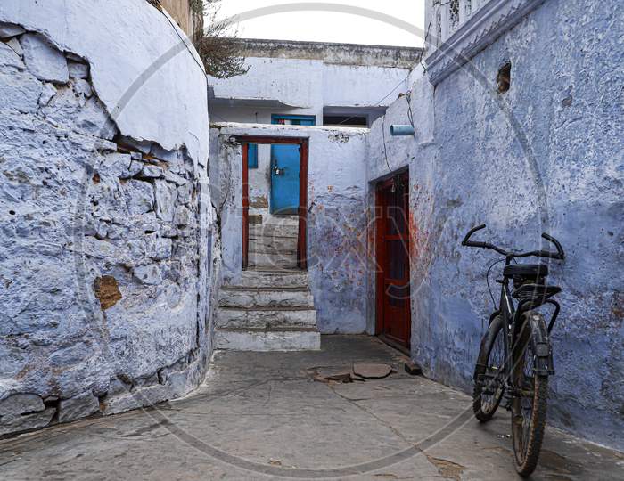 Old bicycle at the wall of blue house in streets  of bharatpur,rajasthan