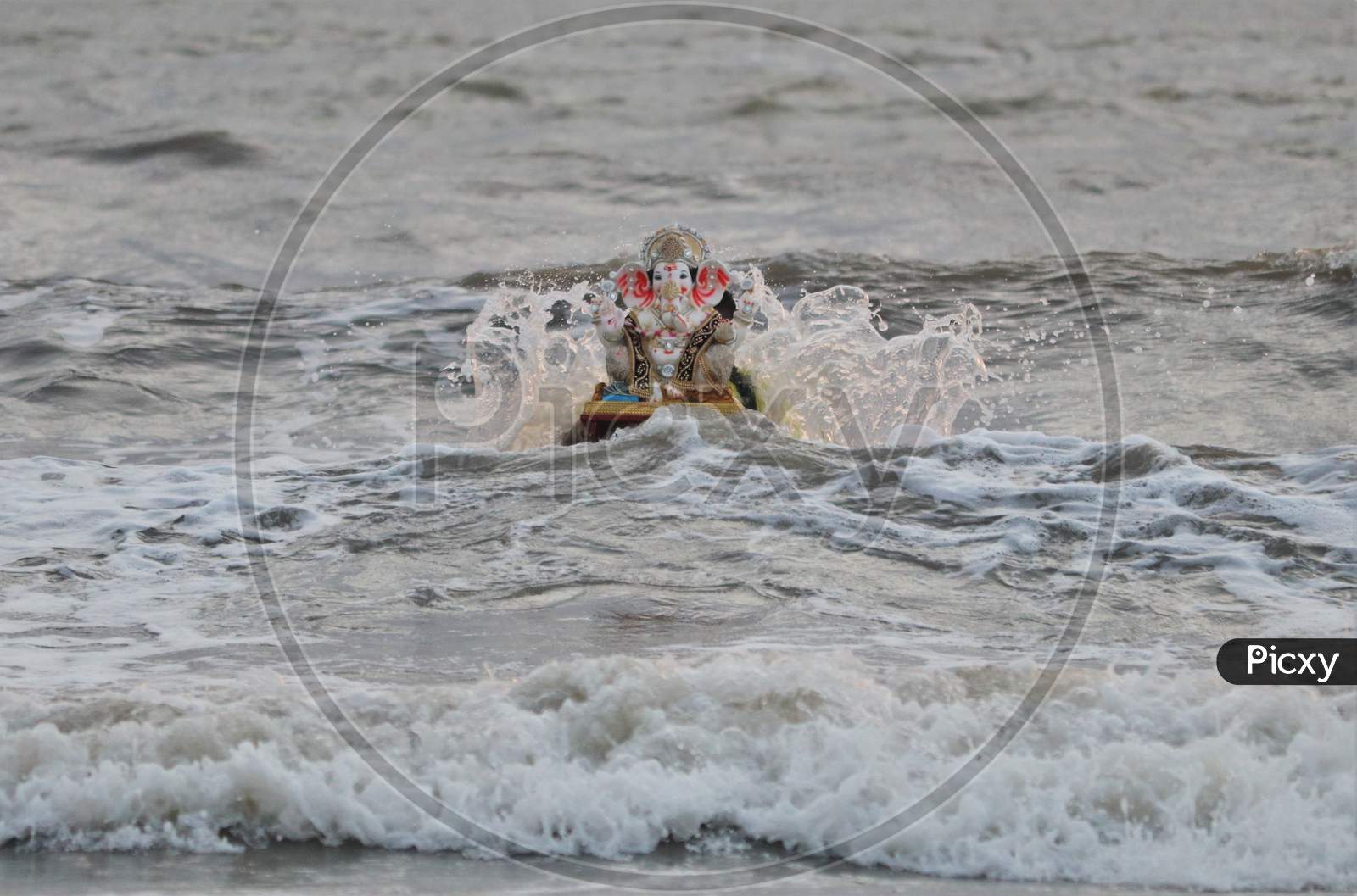A man immerses an idol of the Hindu god Ganesh, the deity of prosperity, into the waters of the Arabian sea on the fifth day of the 10-day long Ganesh Chaturthi festival in Mumbai, India on August 26, 2020.