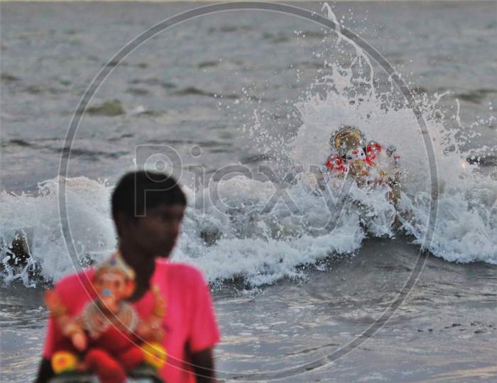 People immerse an idol of the Hindu god Ganesh, the deity of prosperity, into the waters of the Arabian sea on the fifth day of the 10-day long Ganesh Chaturthi festival in Mumbai, India on August 26, 2020.