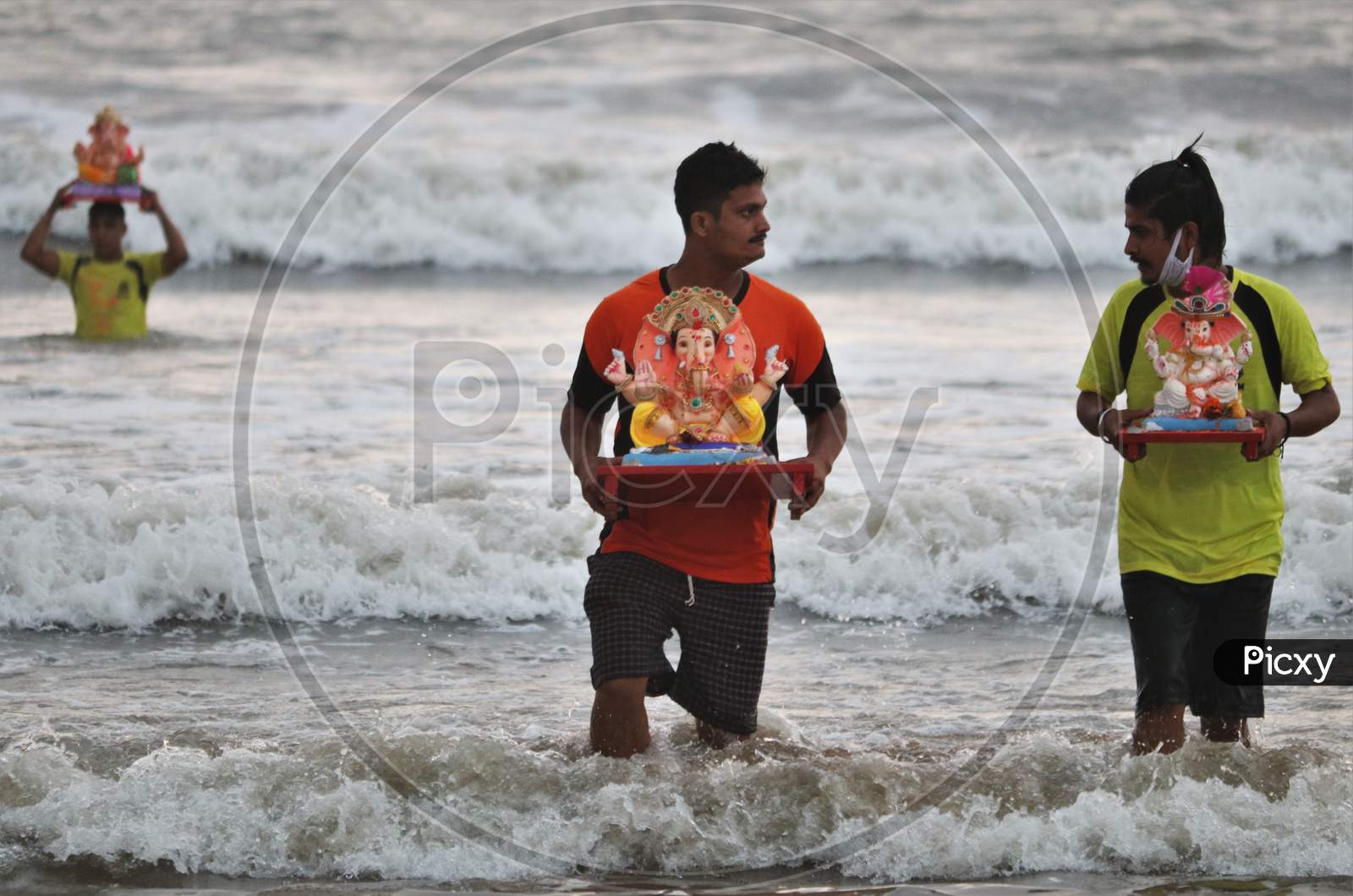 People carry an idol of the Hindu god Ganesh, the deity of prosperity, to immerse it into the waters of the Arabian sea on the fifth day of the 10-day long Ganesh Chaturthi festival in Mumbai, India on August 26, 2020.