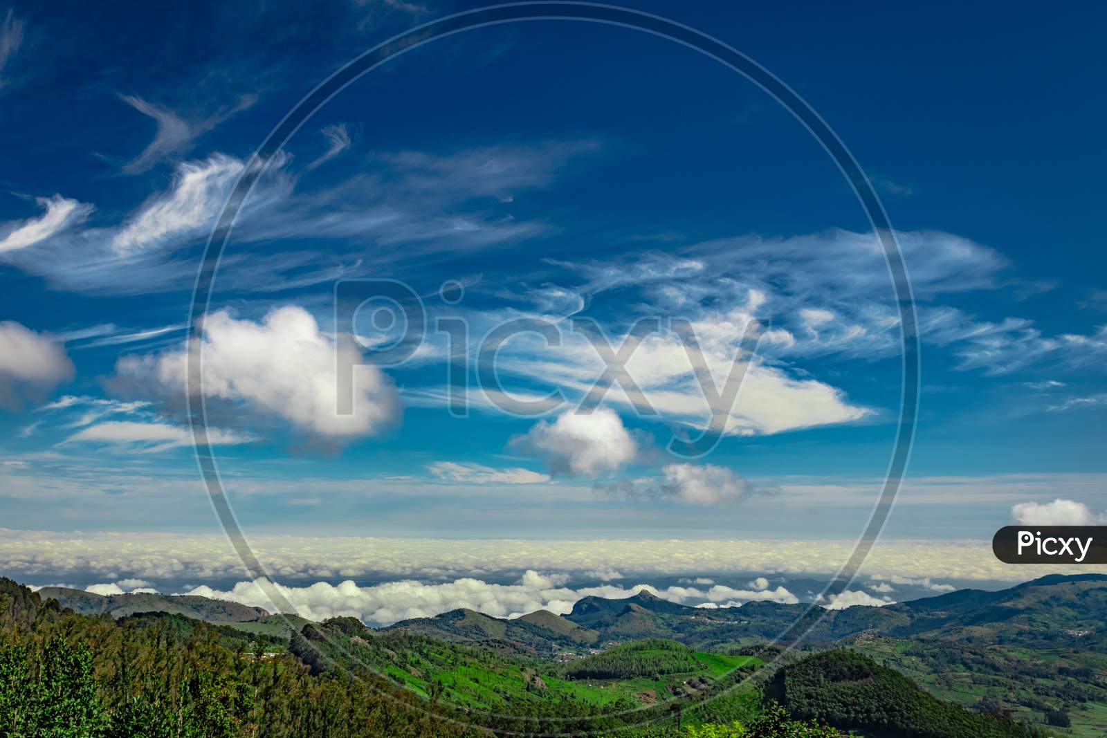 Mountain Range With Cloud Layers And Green Forest