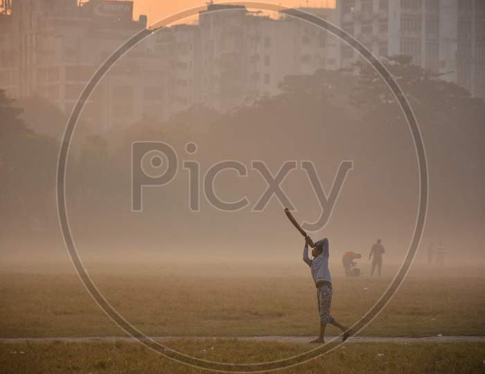 Winter morning day, a boy is practicing cricket.