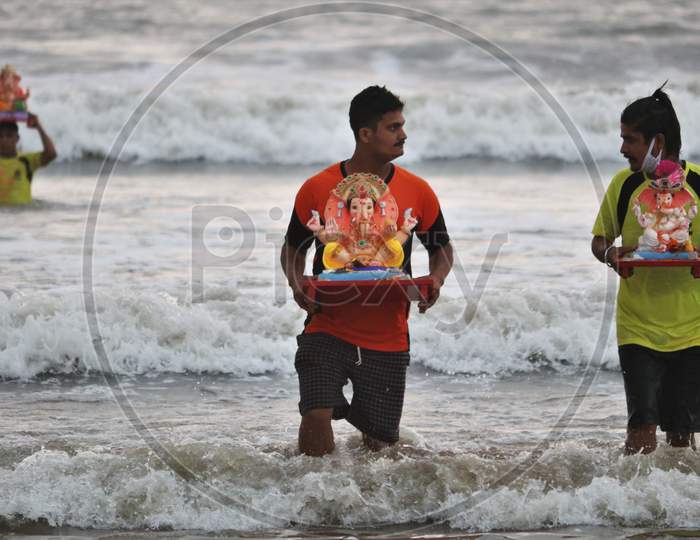 People carry an idol of the Hindu god Ganesh, the deity of prosperity, to immerse it into the waters of the Arabian sea on the fifth day of the 10-day long Ganesh Chaturthi festival in Mumbai, India on August 26, 2020.