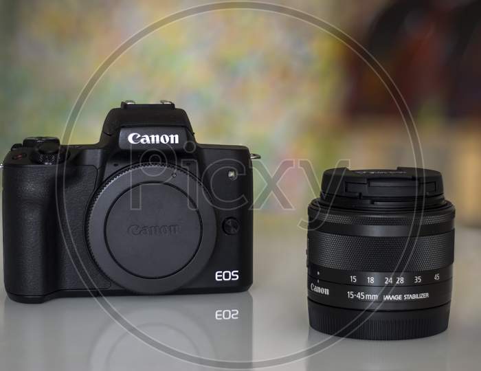 Frankfurt, Germany - 26th August 2020: A german photographer takes pictures of his old Canon EOS M50 with the KIT lens and additional equipment in order to sell it, showing the camera body with lens.