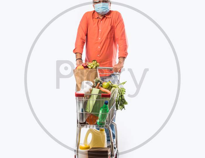 Indian Asian Senior Man Wears Face Mask While Pushing Shopping Trolly Or Cart