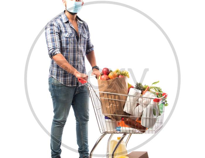 Indian Asian Young Man Wearing Face Mask And Pushing Shopping Trolly Or Cart
