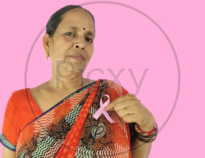 Woman pointing finger on Pink ribbon a symbol of fight against cancer