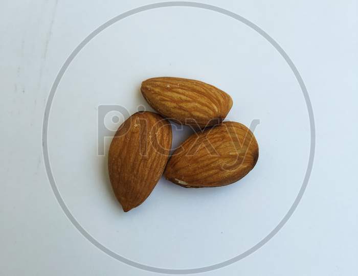 Closeup Of Three Almond Nuts Isolated In A White Background