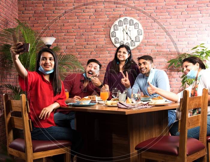 Indian Asian Young Friends Eating Food In Restaurant After Corona Virus Pandemic Or In Unlock Phase