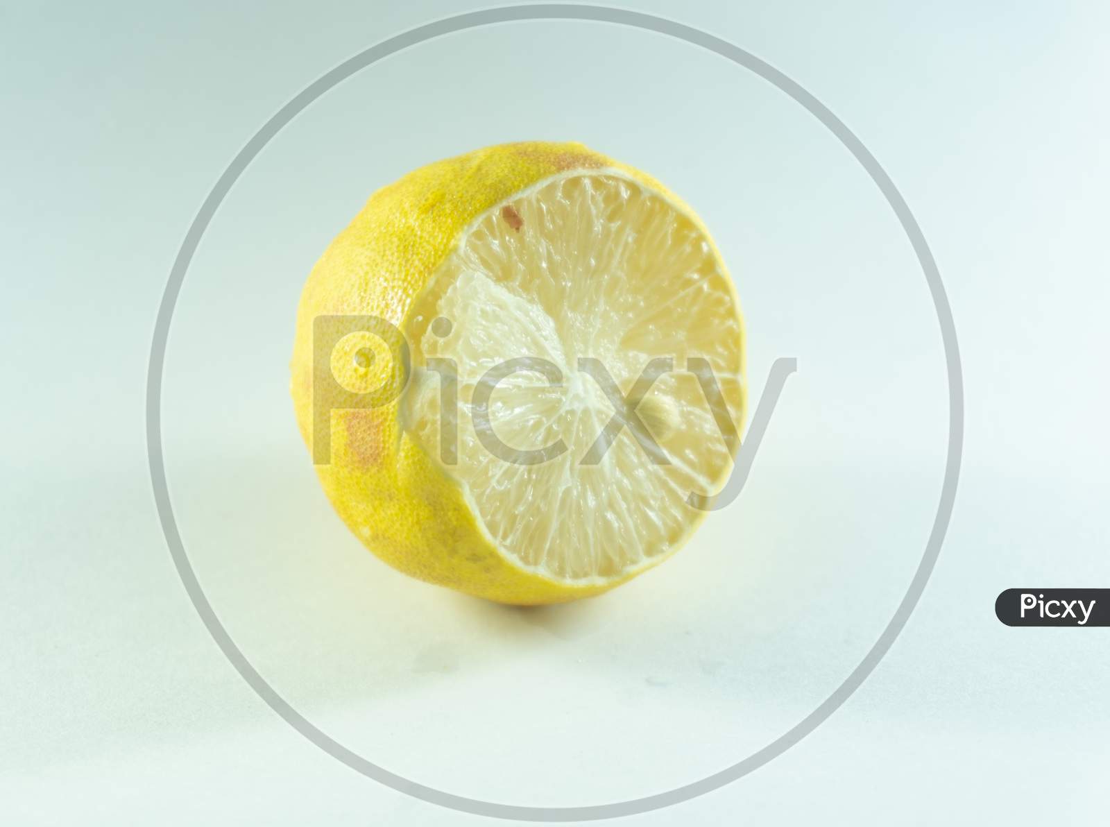 Half sliced lemon filled with juice, and pullpy seeds , citrus sour fruit with clear white background