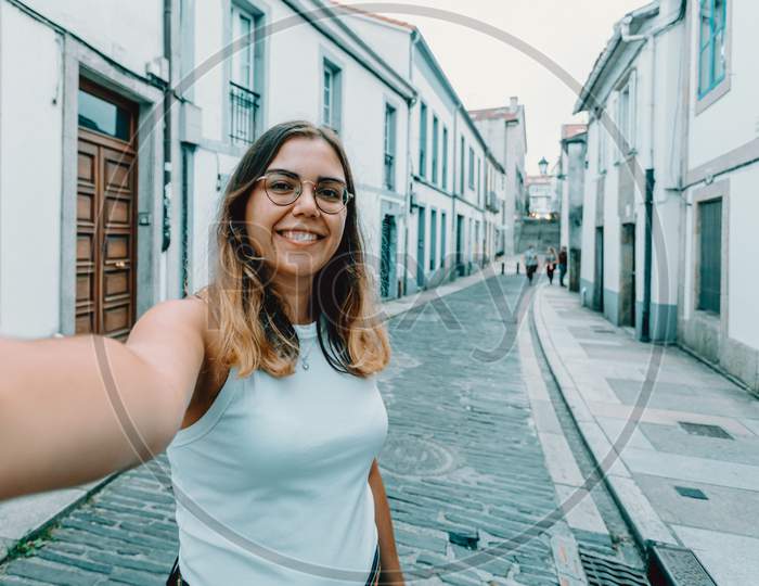 Young Woman With Glasses Taking A Selfie On A Old Spanish Street