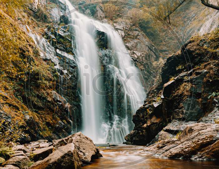 Horizontal Shot Of A Long Exposure Of A Giant Waterfall During Autumn