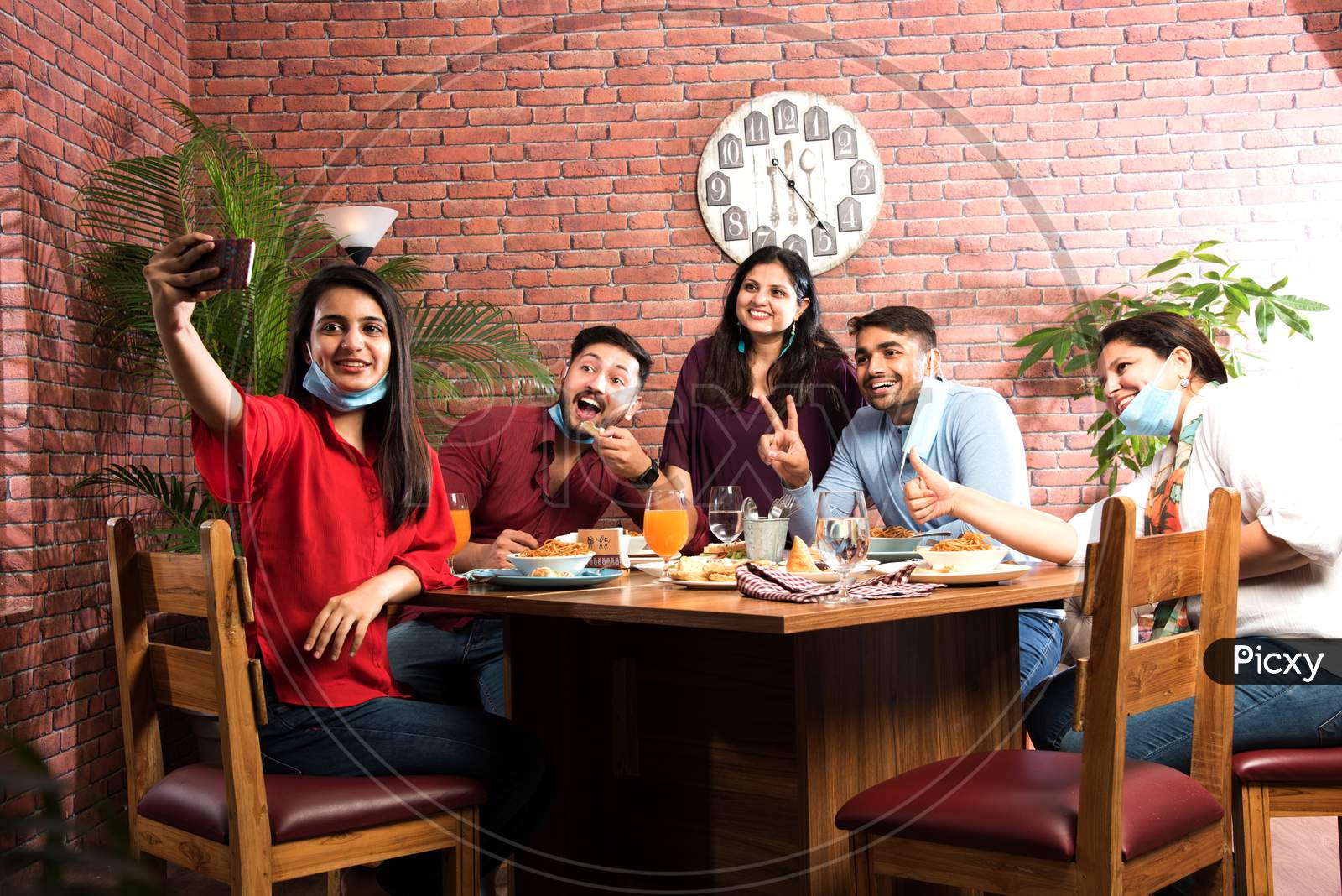 Indian Asian Young Friends Eating Food In Restaurant After Corona Virus Pandemic Or In Unlock Phase
