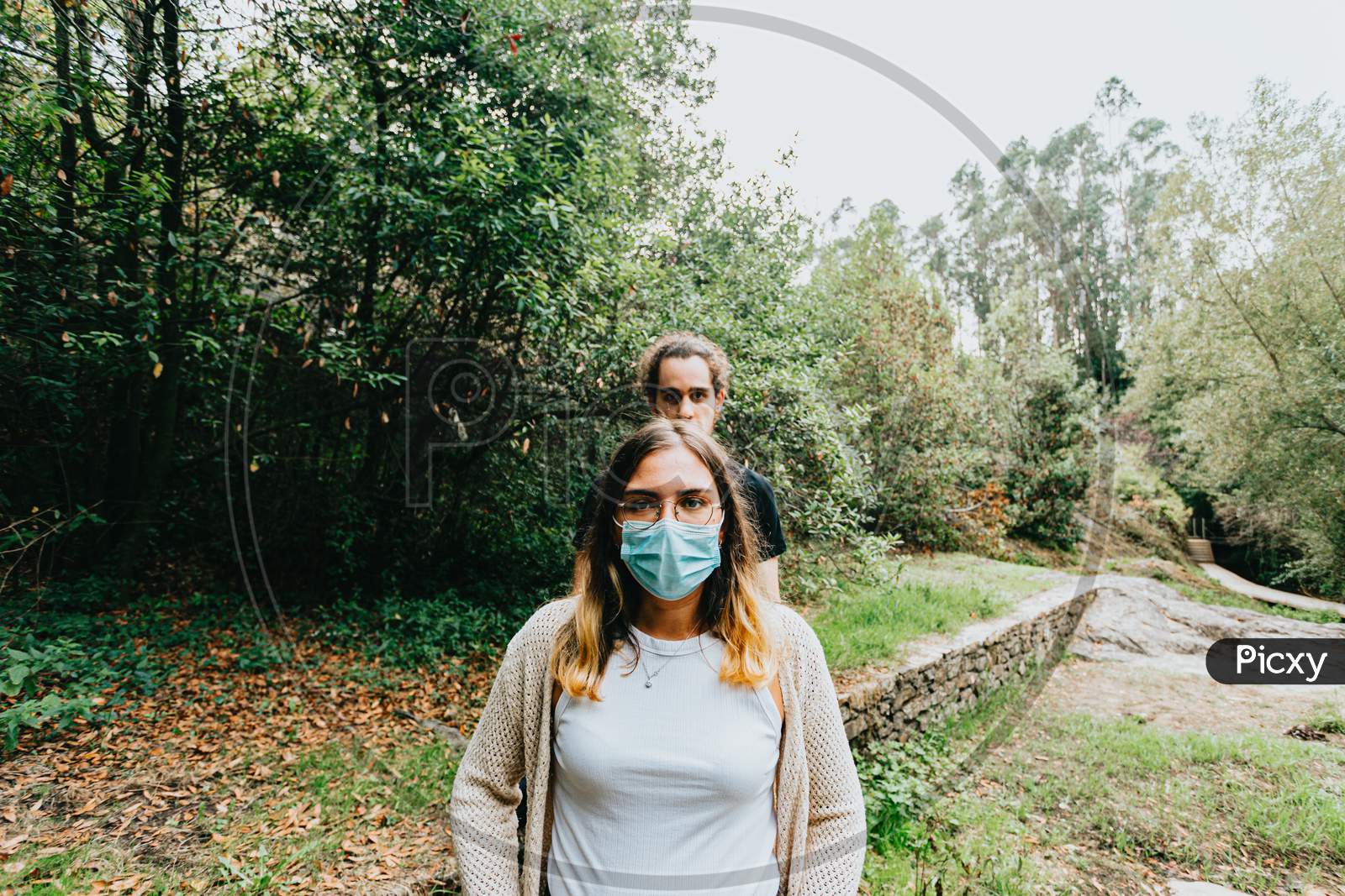 Front Shot Of A Serious Couple With The Masks Put On In The Forest