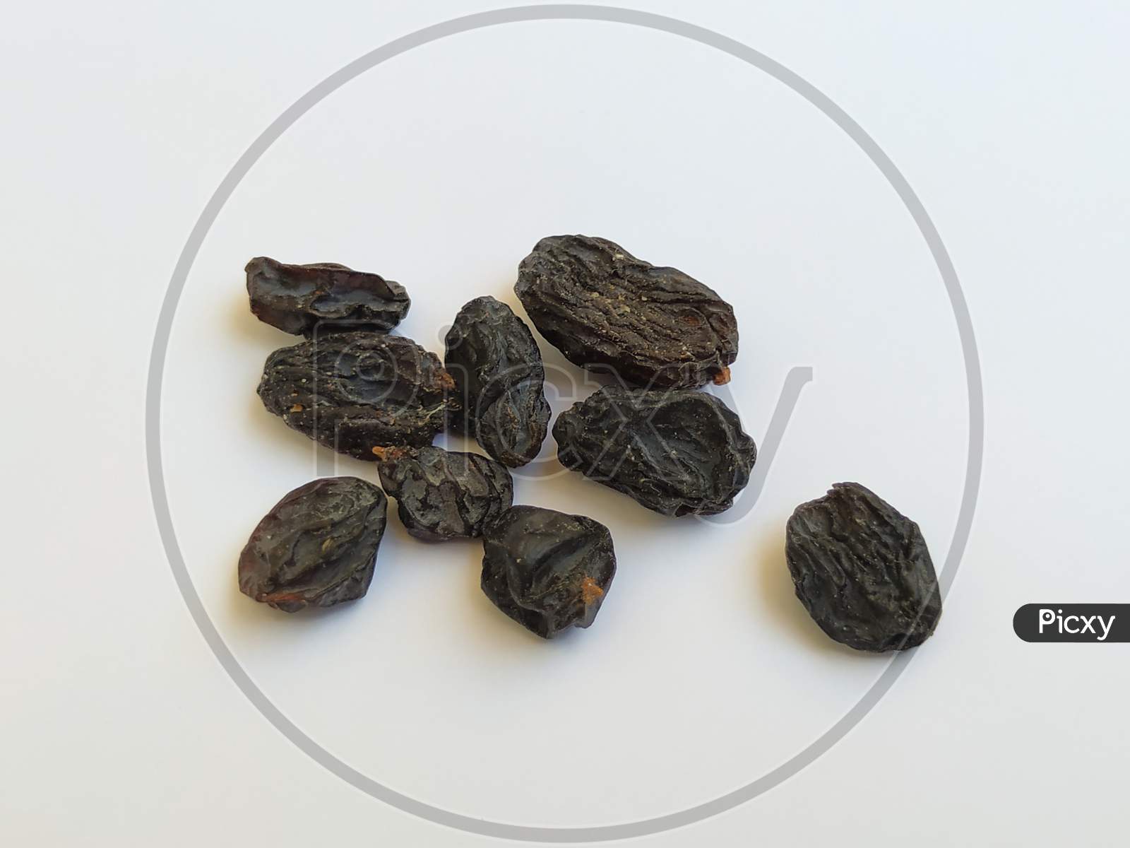 Closeup Of Dry Black Raisin Fruit Isolated In A White Background. Heap Of Blue Raisin Isolated On White
