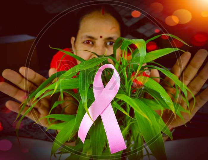 Woman Behind Pink ribbon a cancer survivor, Selective focus on ribbon