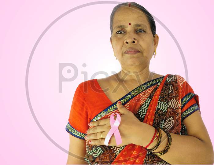 Indian woman Hand holding pink ribbon , Breast cancer awareness symbol, fight against cancer