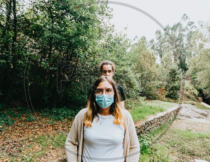 Front Shot Of A Serious Couple With The Masks Put On In The Forest