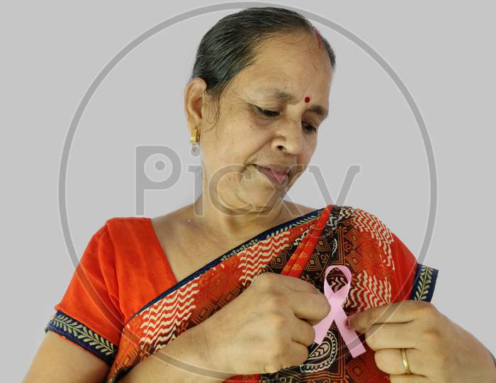 Woman pointing finger on Pink ribbon a symbol of fight against cancer