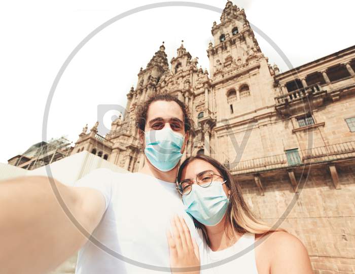 Young Couple Taking A Selfie In A Touristic Place With The Masks On