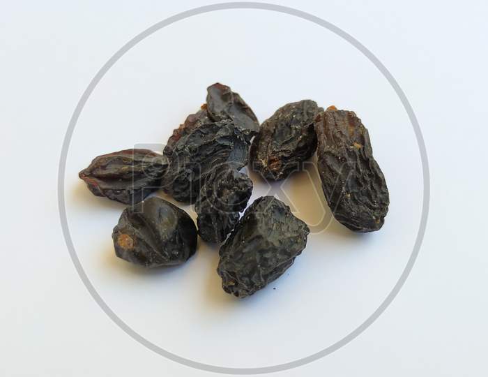Closeup Of Dry Black Raisin Fruit Isolated In A White Background. Heap Of Blue Raisin Isolated On White