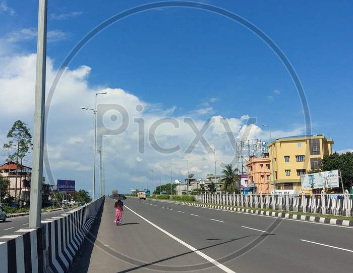 View of Asian Highway A lady walking on the road in the hot sunny day with umbrella