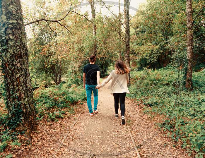 Young Couple Taking A Walk In The Park On Autumn